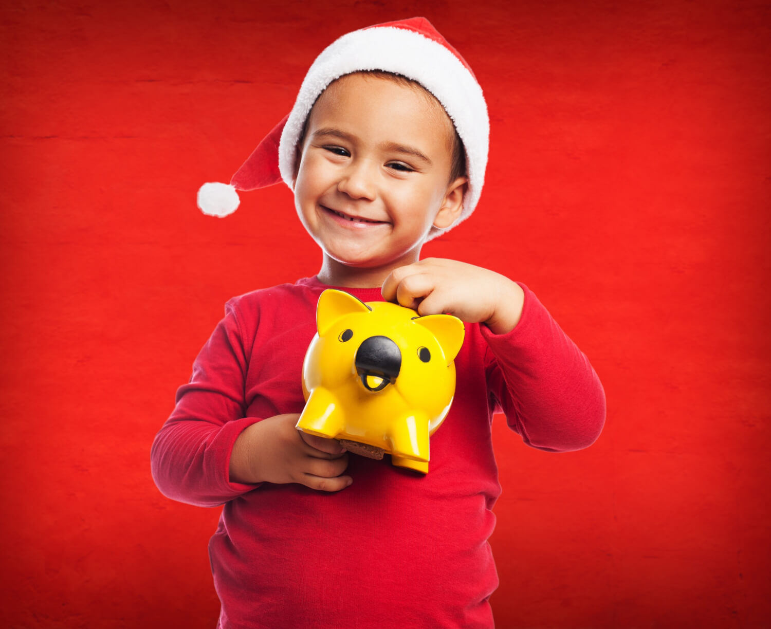Kind mit Spardose und Weihnachtsmütze
